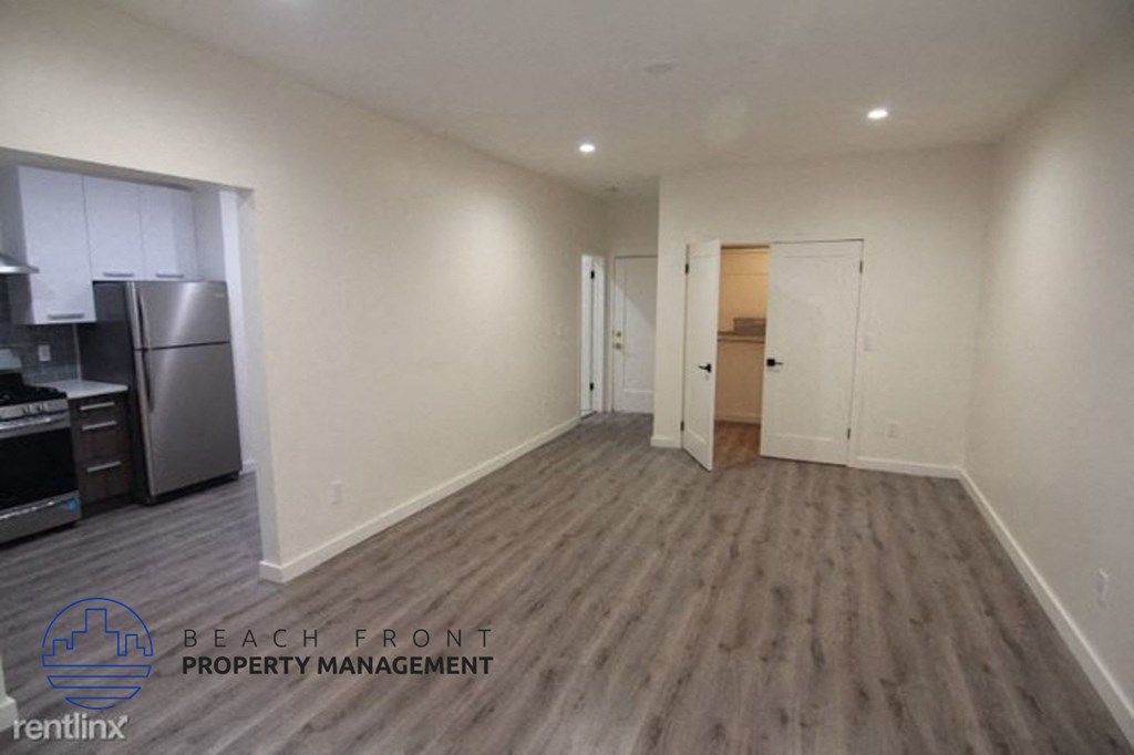 an image of a hallway with wood flooring and white walls