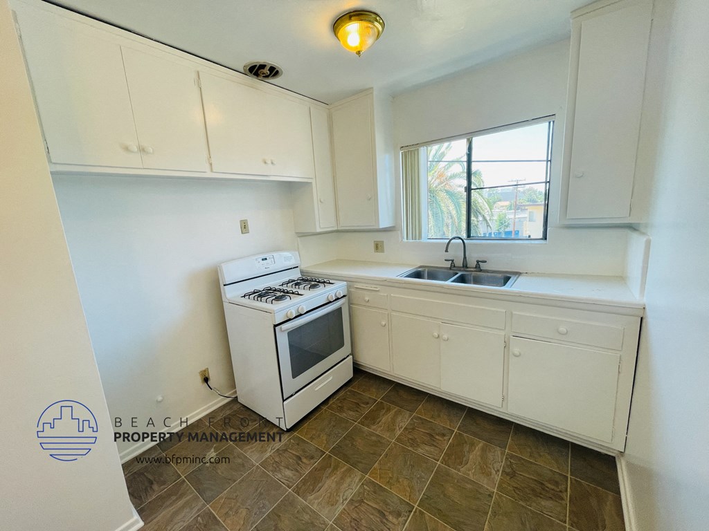 a small kitchen with white cabinets and a stove and a sink