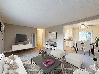 A living room with a grey coffee table and white couches.