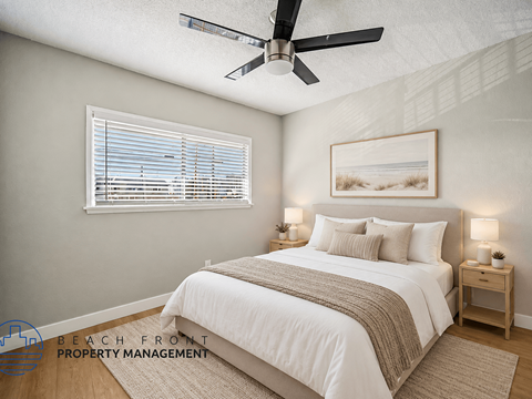 A bedroom with a bed, nightstands, and a ceiling fan.