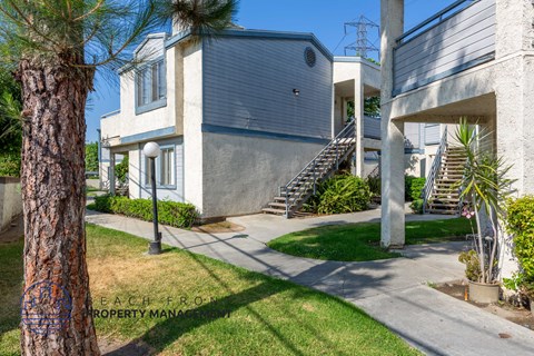 A modern house with a concrete exterior and a staircase leading to the entrance.