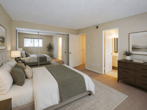 A bedroom with a large bed and a dresser.
