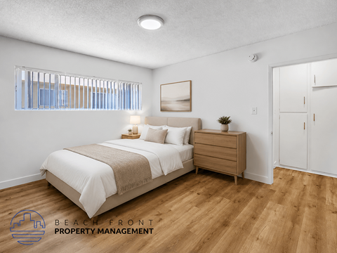 A bedroom with a bed, nightstand, and a window with blinds.