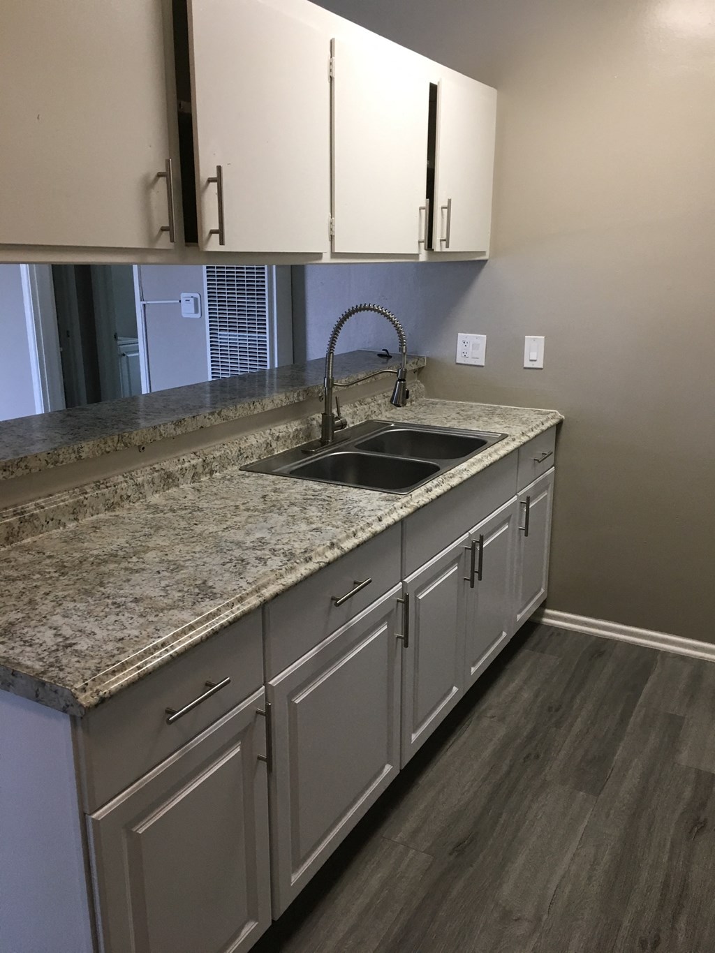 a kitchen with white cabinets and granite counter tops and a sink