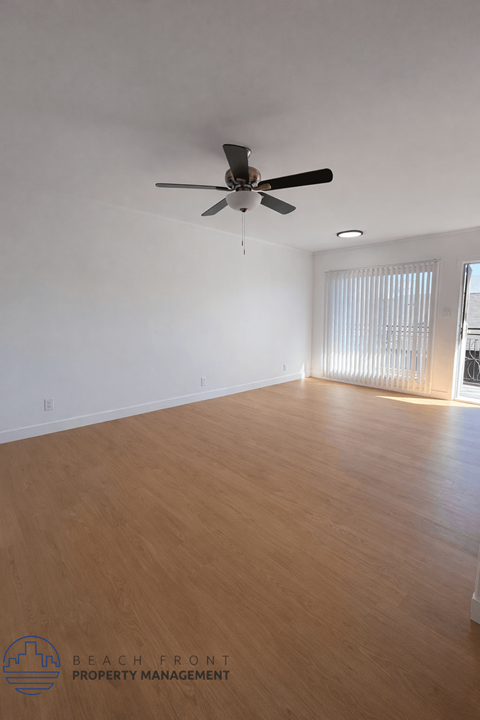 A room with a ceiling fan and wooden flooring.