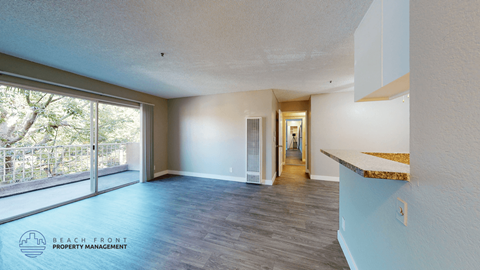 A spacious room with a view of the trees through the sliding glass doors.