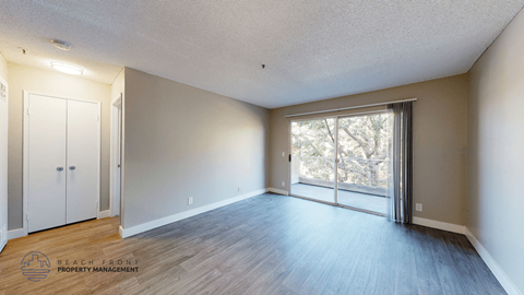 A room with a sliding glass door leading to a balcony.