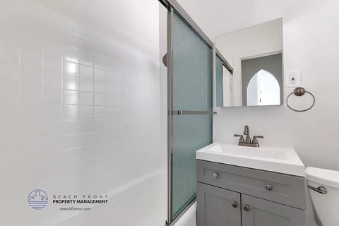 A bathroom with a white sink and a mirror above it.