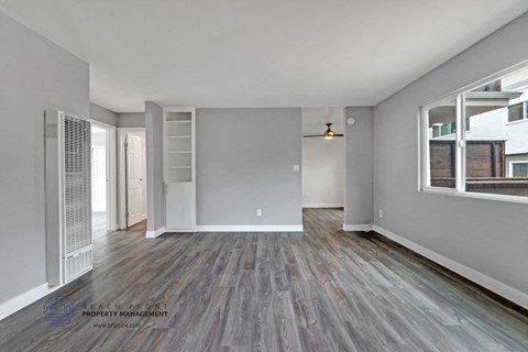 the living room of an apartment with grey walls and wood flooring