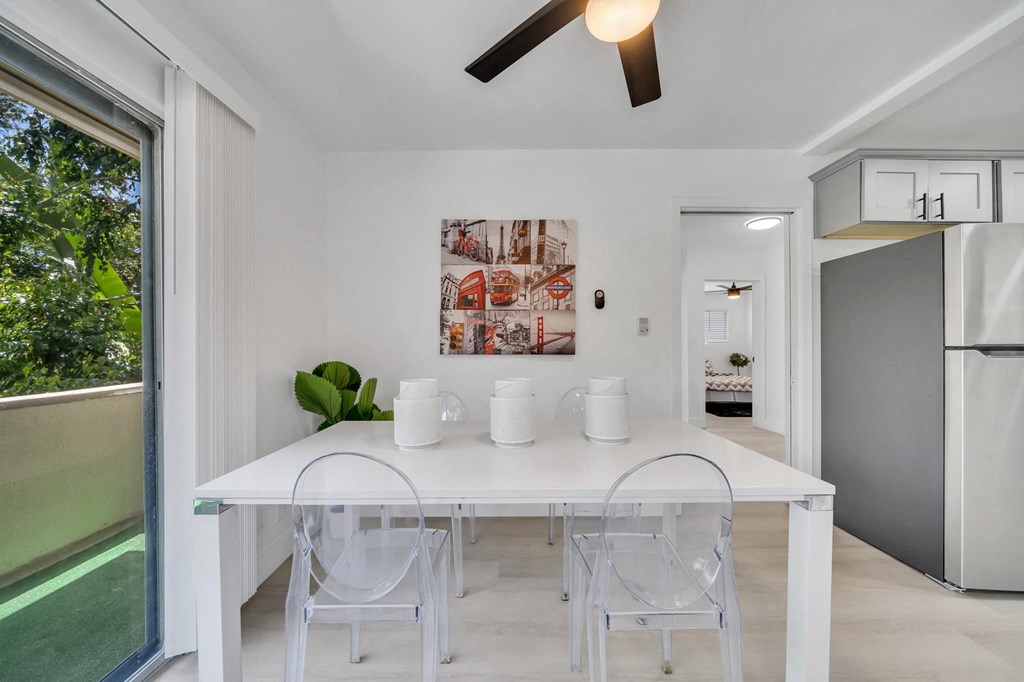 a white dining room with a white table and chairs