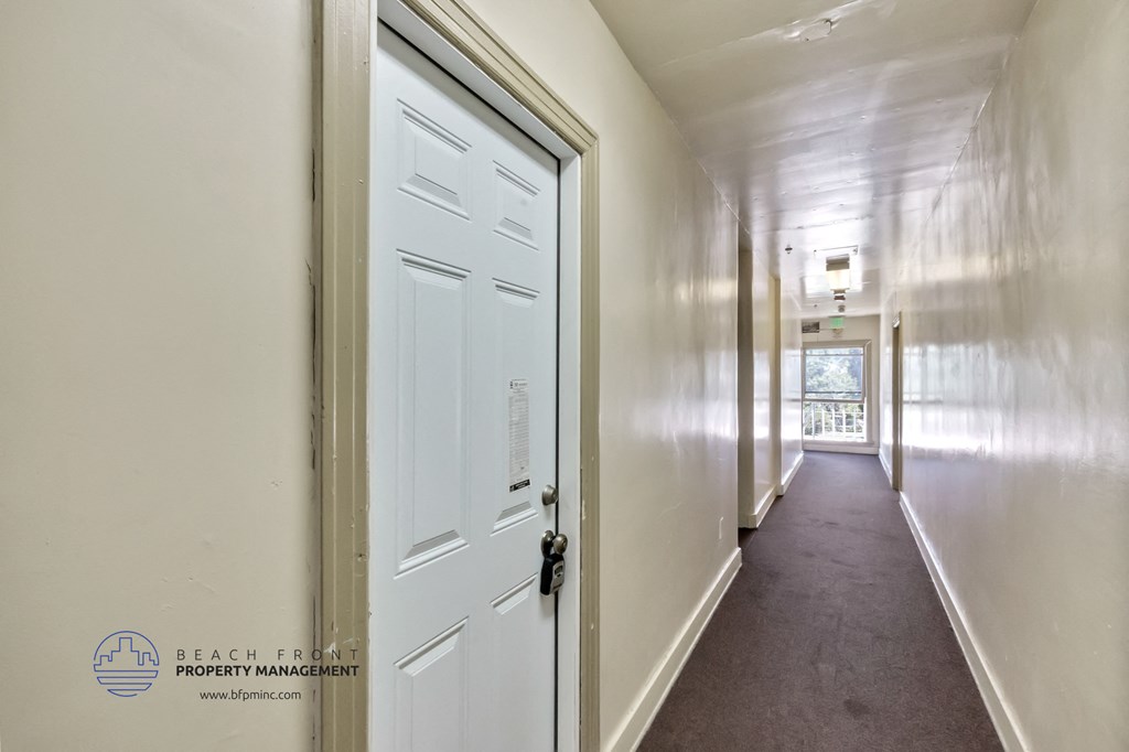 a long hallway with white doors and white walls