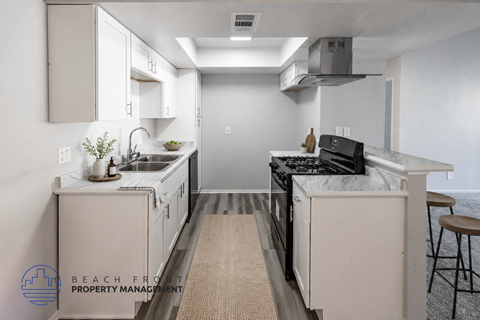 A kitchen with a stove top oven and a sink.