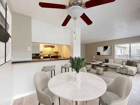 A living room with a white marble table and grey chairs.