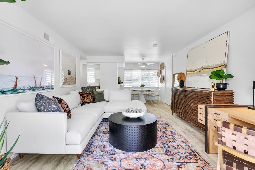 A living room with a white couch and a rug.