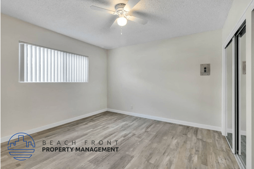 an empty room with white walls and a ceiling fan