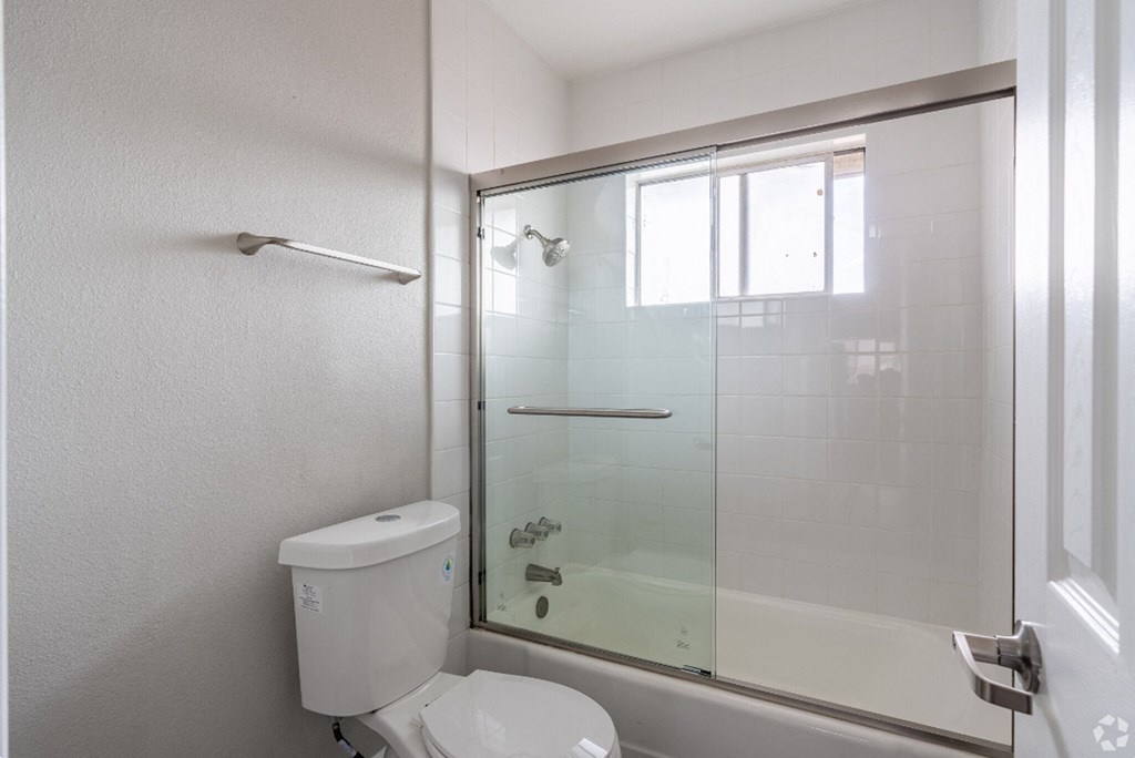 an empty bathroom with a shower and a toilet