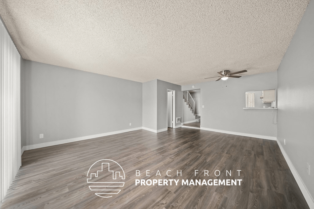a living room with wood floors and a ceiling fan