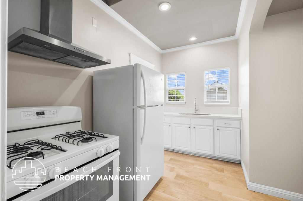 a white kitchen with a stove and refrigerator and a sink