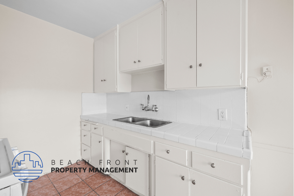 a white kitchen with white cabinets and a sink