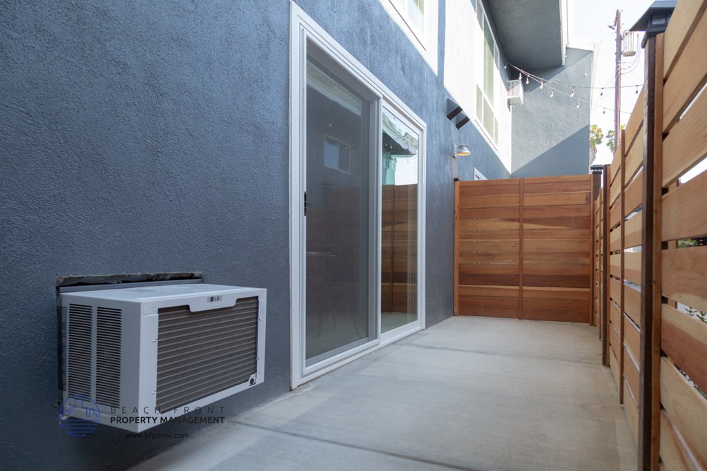 A modern house with a white air conditioner unit on the side.