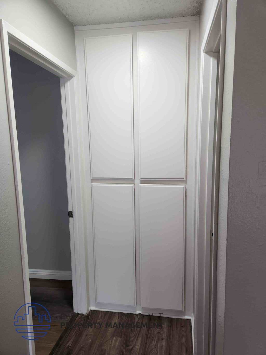 A white door in a room with a logo on the bottom left.