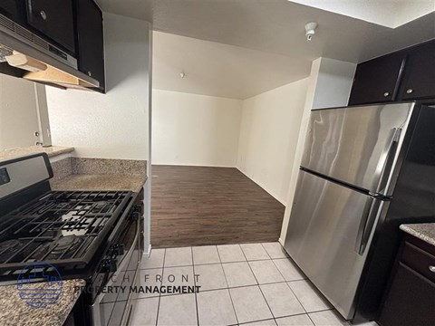 A kitchen with a stove top oven and a refrigerator.