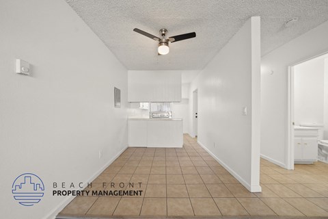 A spacious room with a ceiling fan and tiled floor.