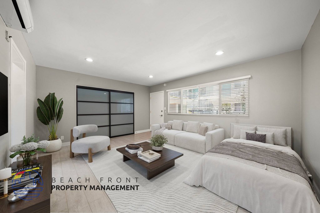 A well-lit bedroom with a large bed and a window with blinds.