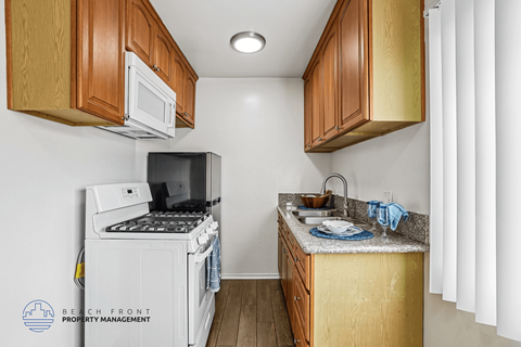 A kitchen with wooden cabinets and a white refrigerator.