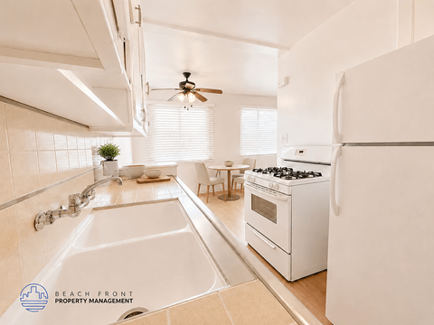 A white kitchen with a sink and a stove.