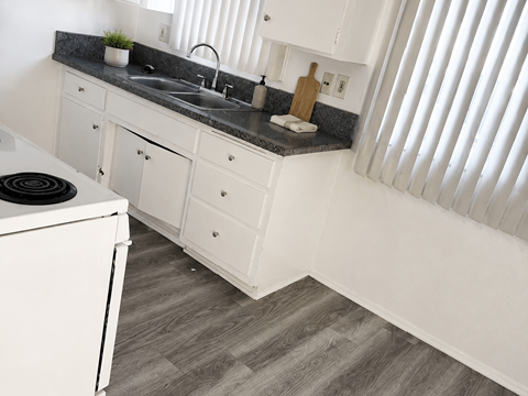 A kitchen with white cabinets and a black stove top.