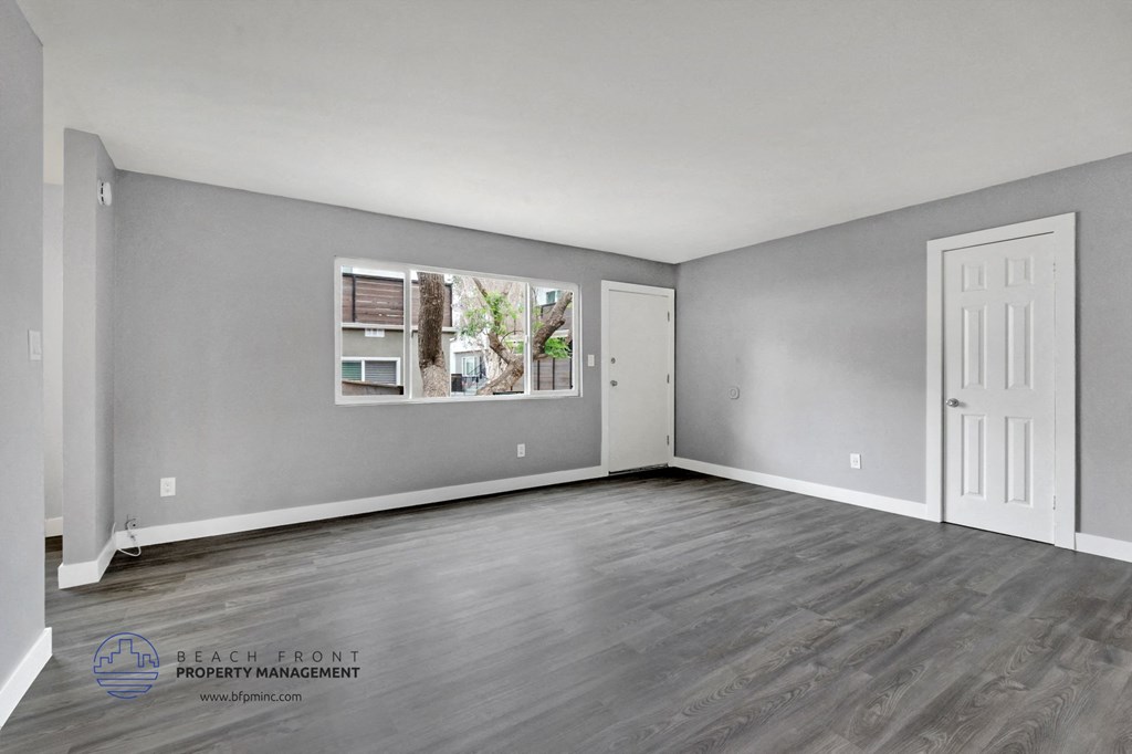the living room of an apartment with grey walls and a white door