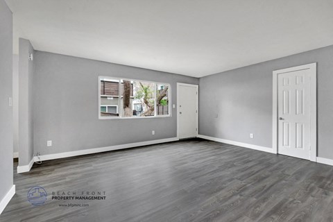 the living room of an apartment with grey walls and a white door