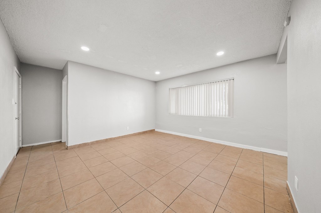 the spacious living room with tiled floor and white walls