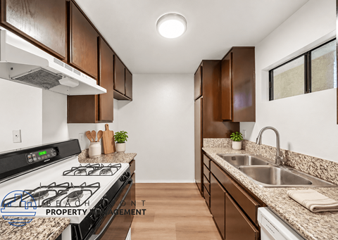 A kitchen with a stove top oven and a sink.