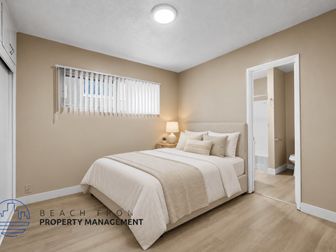A bedroom with a bed, pillows, and a lamp.