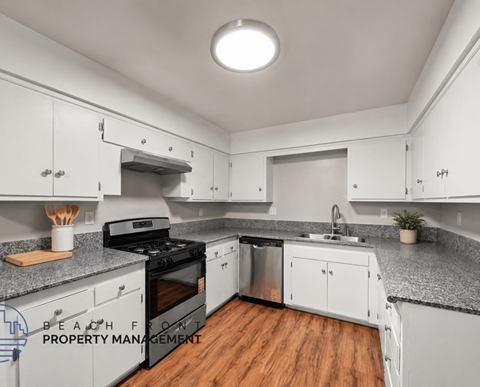 A kitchen with white cabinets and a black stove top oven.