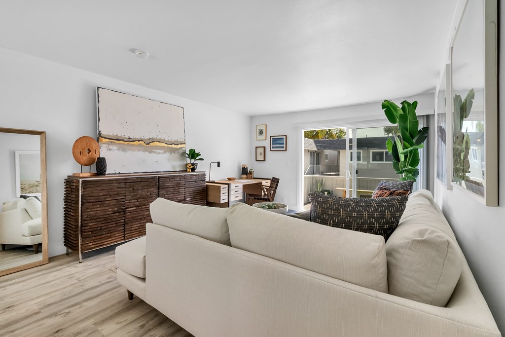 A living room with a white couch and a wooden cabinet.
