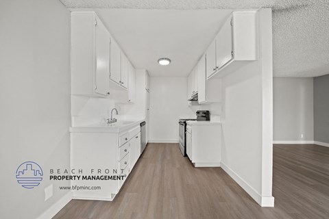 a white kitchen with white cabinets and a wood floor