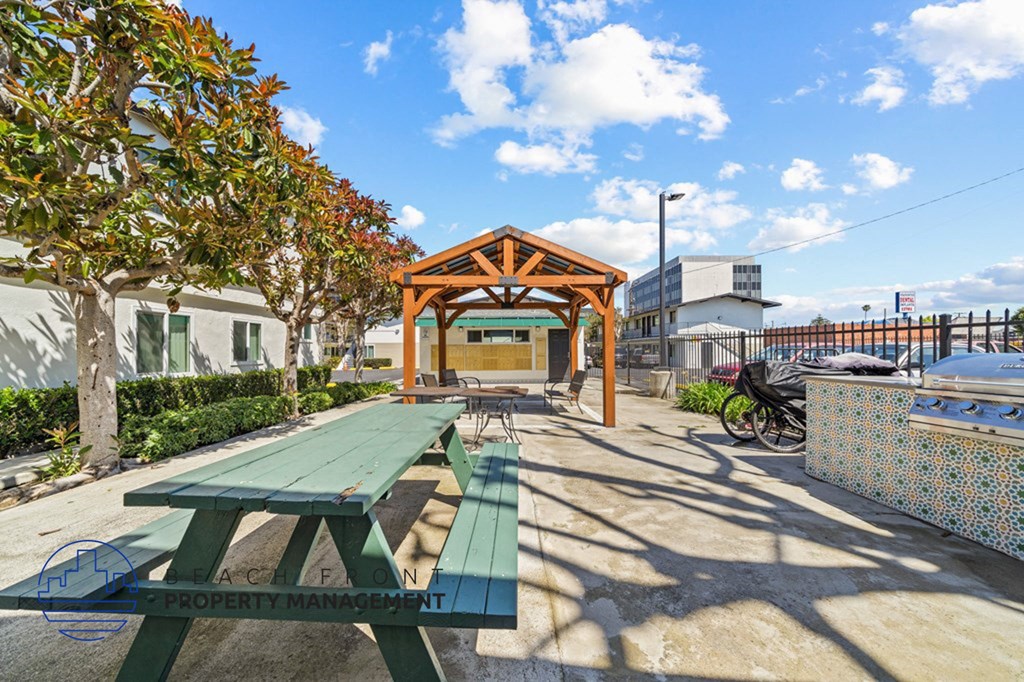 a picnic area with benches and a wooden pavilion