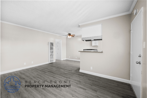 a living room with a kitchen and a ceiling fan