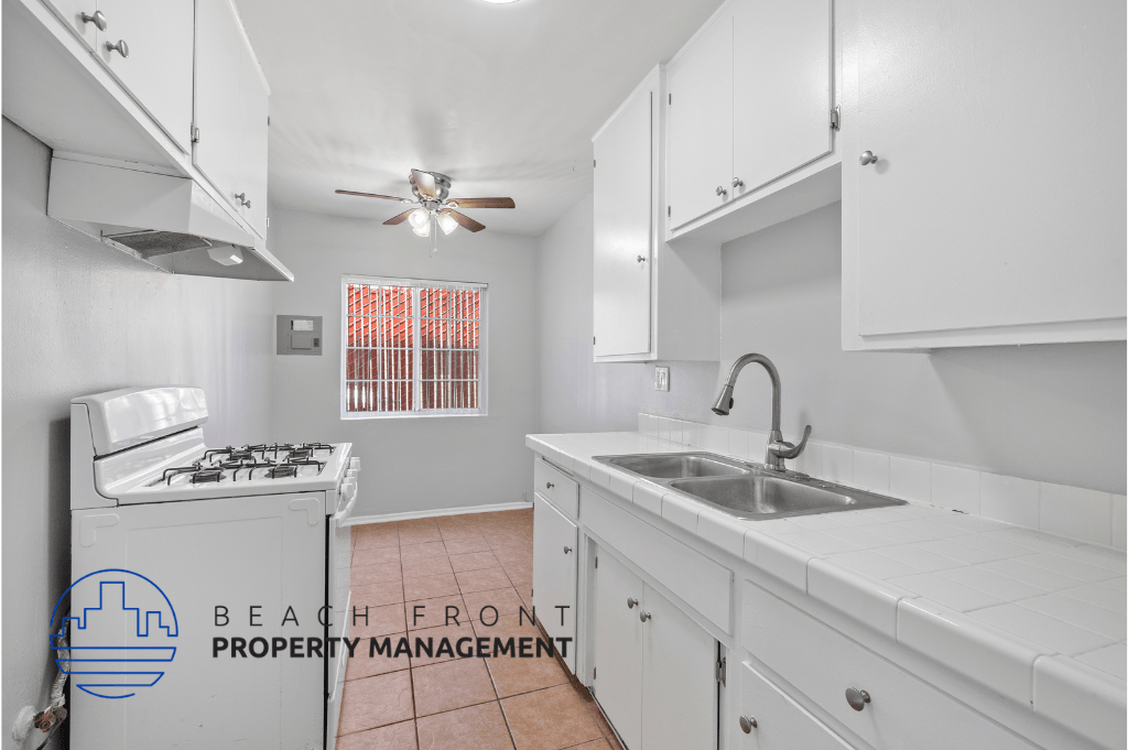 a kitchen with white cabinets and a sink and a stove