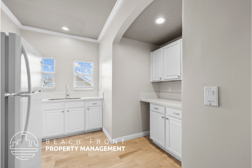 a white kitchen with white cabinets and a refrigerator