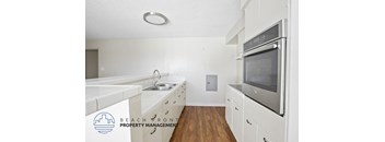 A kitchen with white cabinets and a stainless steel oven.
