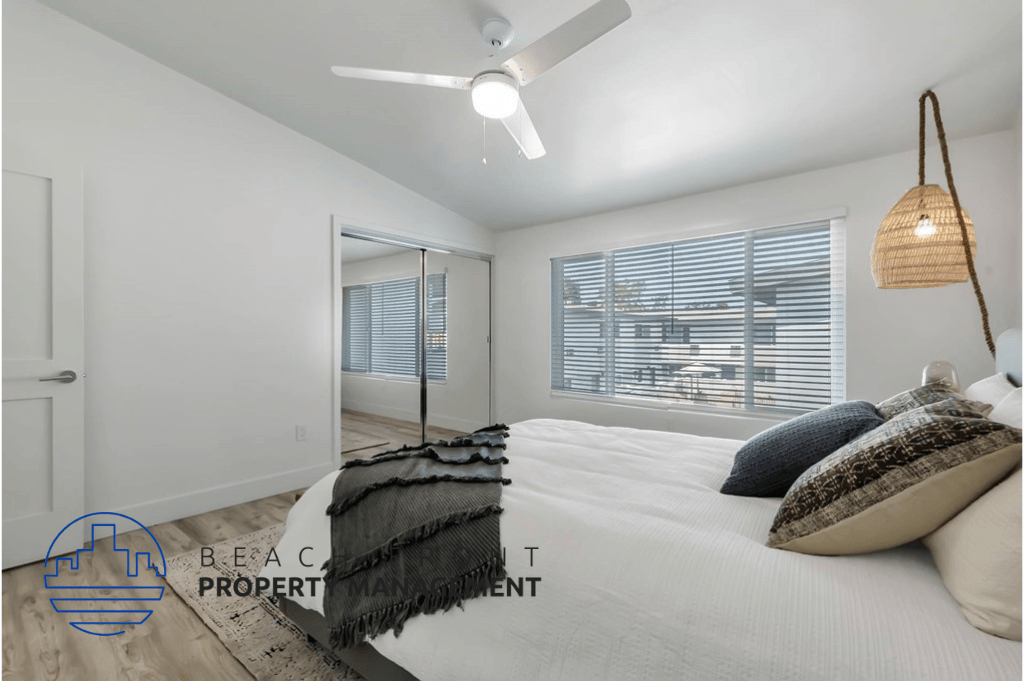 a bedroom with a large white bed and a ceiling fan