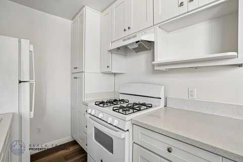 A white kitchen with a stove and cabinets.