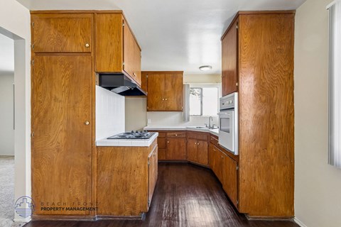 A kitchen with wooden cabinets and a stove top oven.