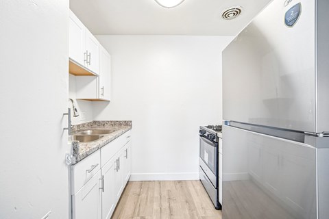 A kitchen with white cabinets and a stainless steel oven.