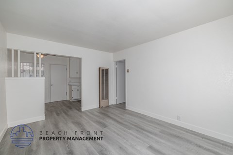 A spacious room with a logo for Beach Front Property Management in the corner.