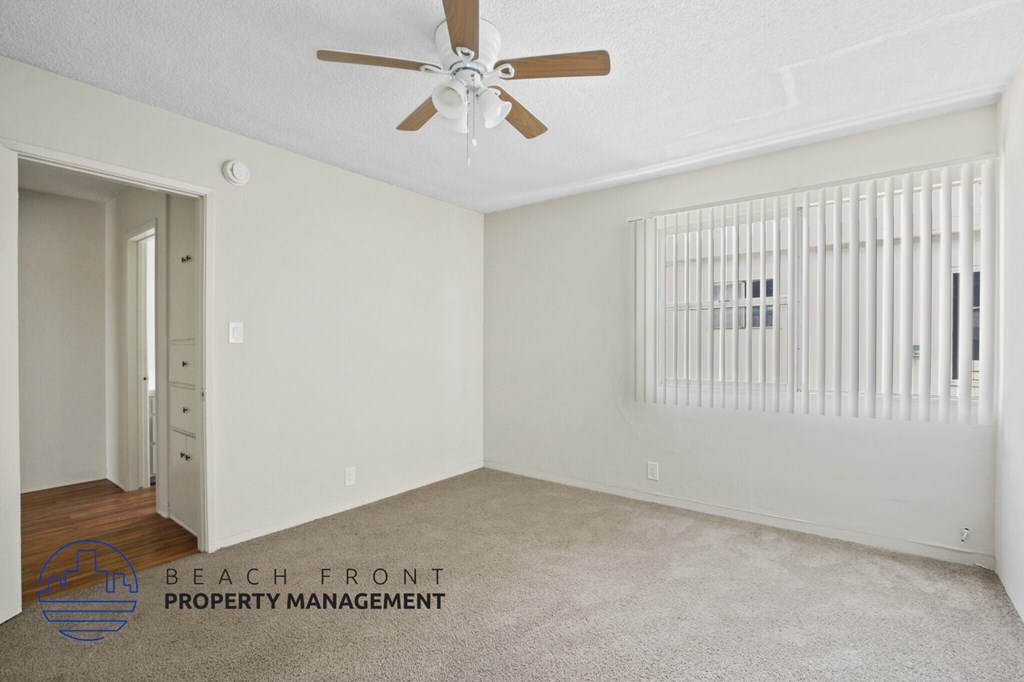 A room with a ceiling fan and a radiator on the wall.